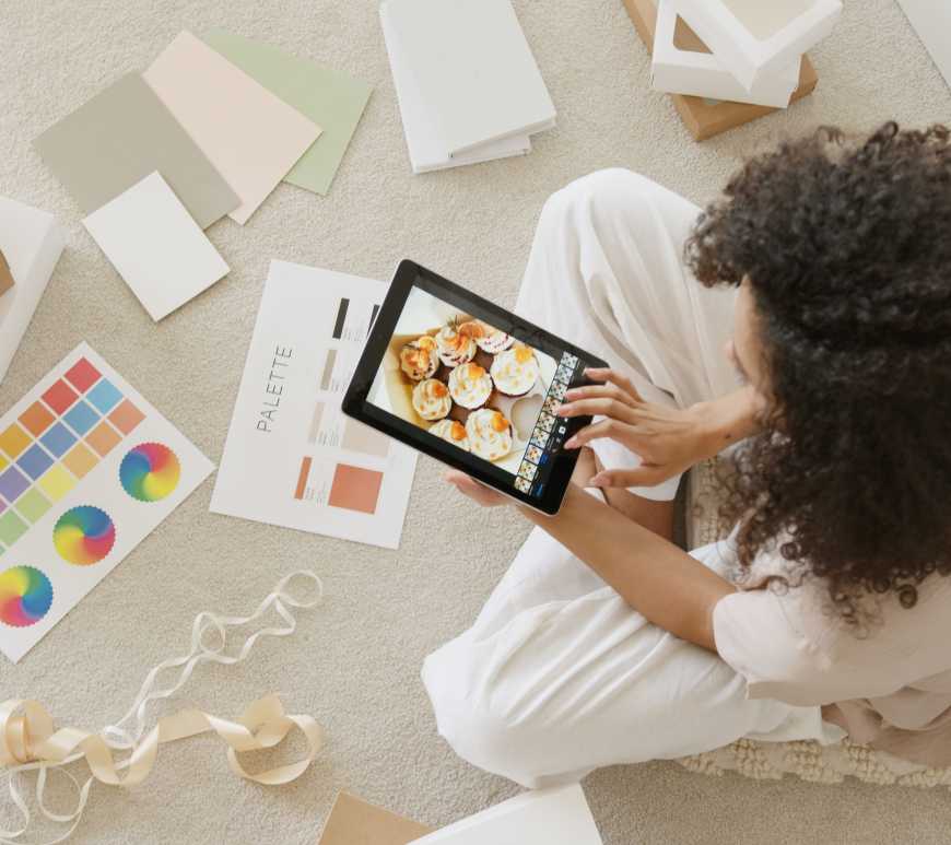 mujer trabajando en sus diseños y fotografías en una tablet