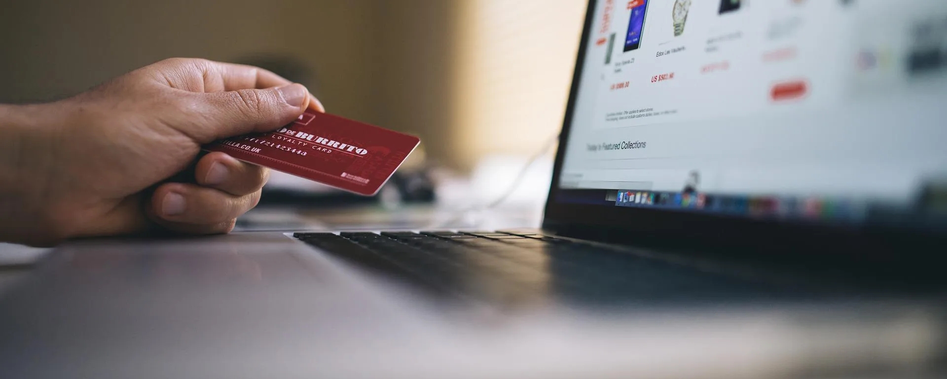Persona usando su tarjeta de crédito para comprar algo en una tienda en línea.